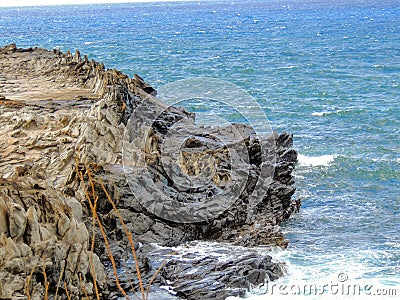 Coastline and rugged lava rocks called Dragonâ€™s Teeth and crashing waves at Makaluapuna Point near Kapalua, Maui, HI, USA Stock Photo